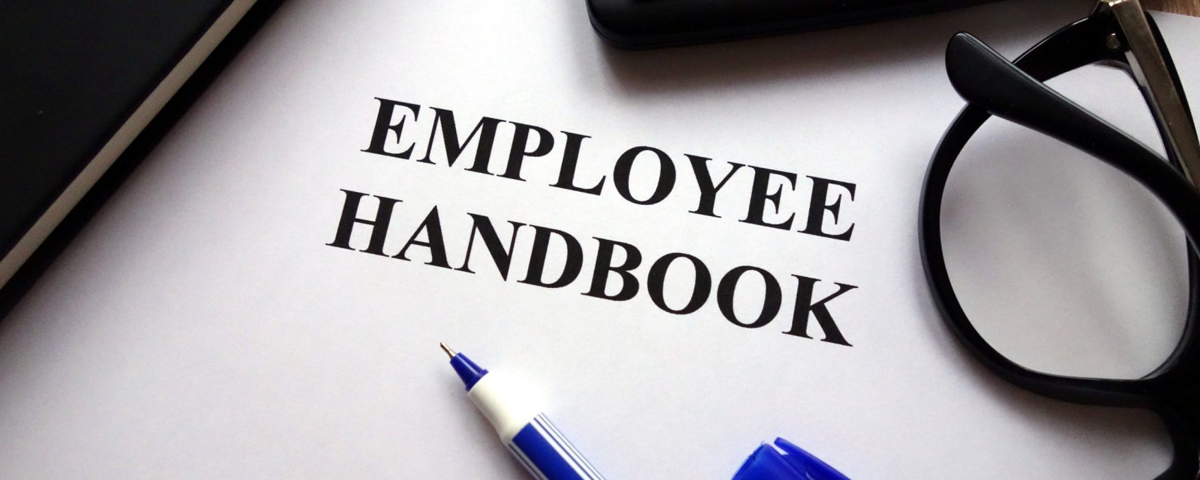 Image of a piece of paper with the words "employee handbook" printed on it