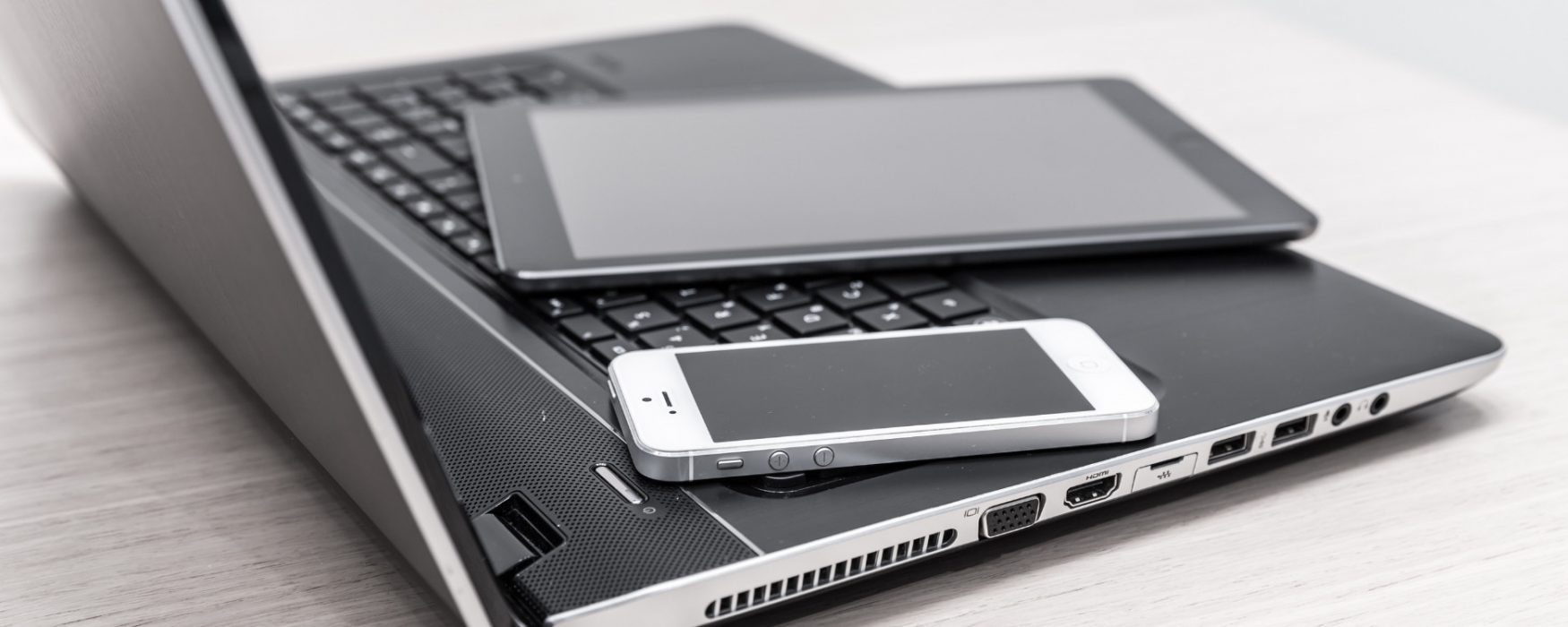 Image of three electronic devices stacked on each other and placed on a tabletop
