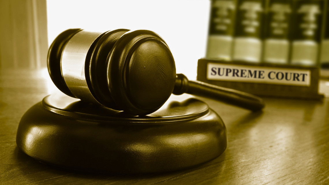 Image of a supreme court sign and gavel on a desk