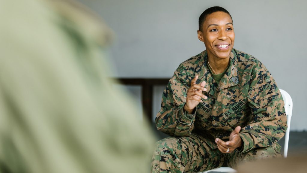 a person in a military uniform is talking to another person