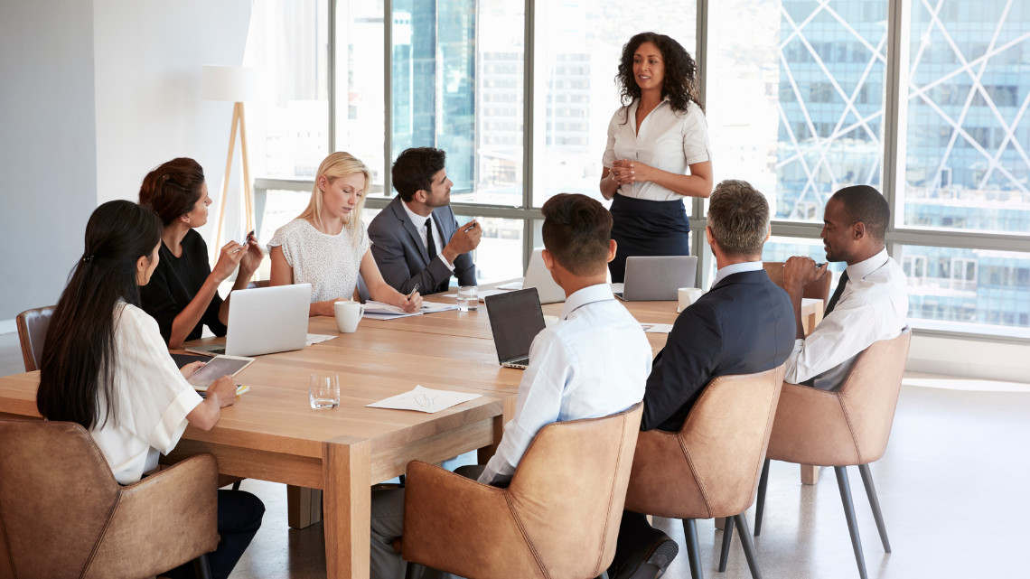 image of a group of employees sitting around a table for meetings