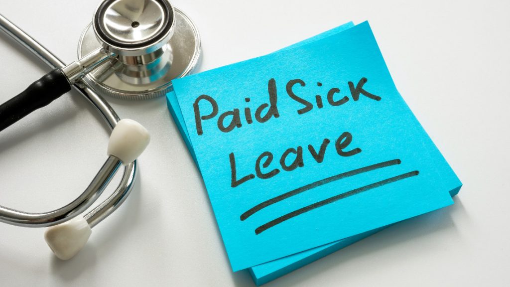 image of a stethoscope sitting next to a post-it note with the words 'paid sick leave' written on it