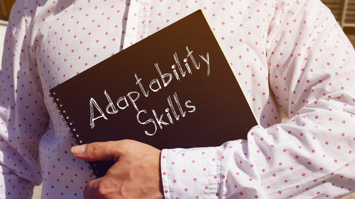 placeholder image of a person holding a binder with the words adaptability skills on it