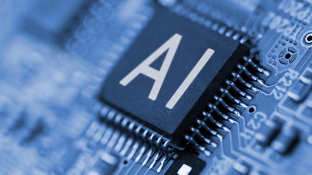 Close-up of a black computer chip labeled "AI" on a circuit board.