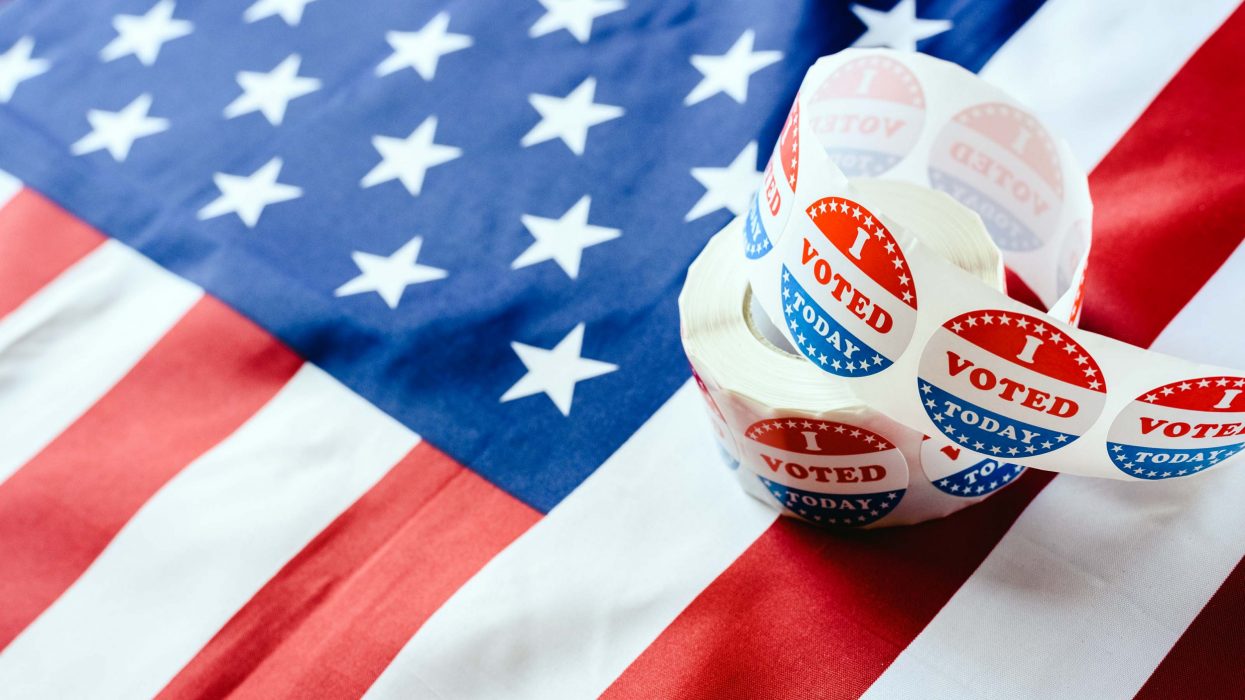 Roll of "I VOTED TODAY" stickers on an American flag representing the results of an election.