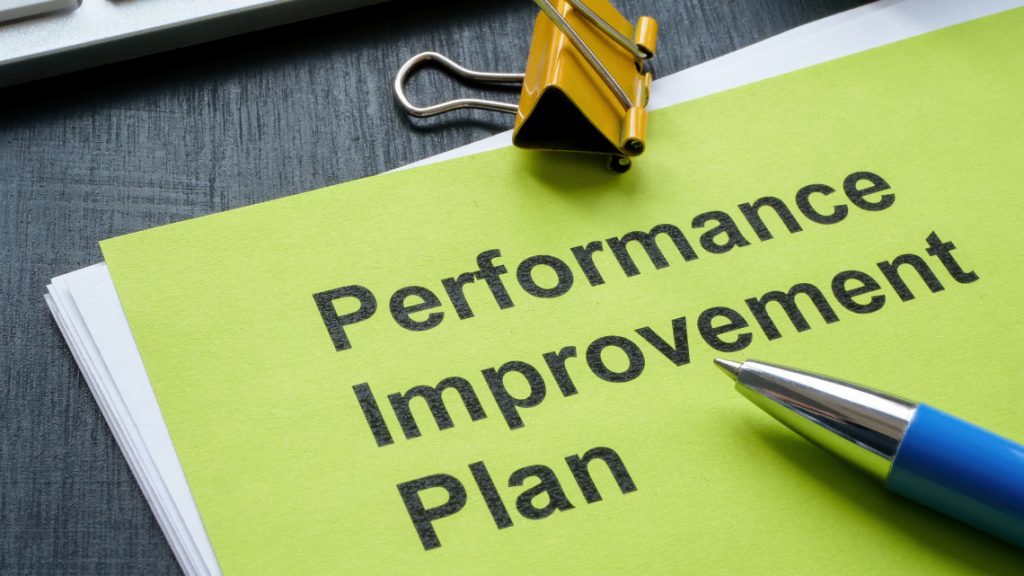 performance improvement plans form sitting on a desk under a pen