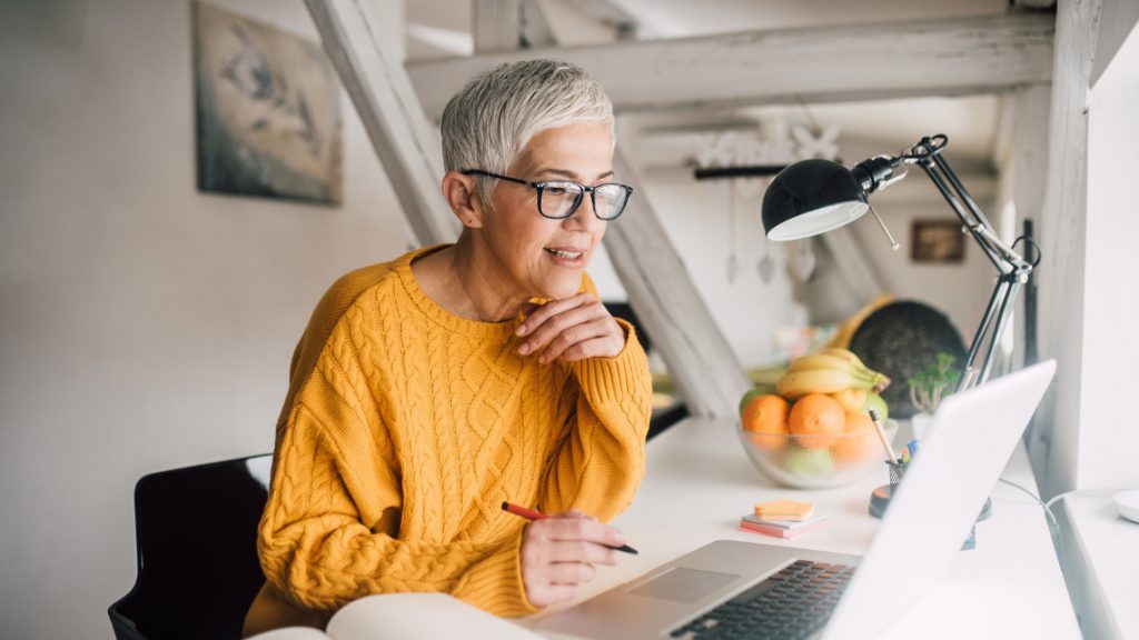 Older person working in front of a laptop computer